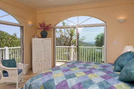A spacious bedroom featuring a large bed and sliding glass doors that open to a scenic outdoor view.
