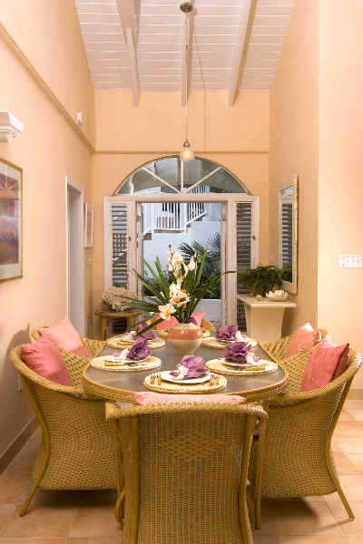 A dining room featuring wicker chairs surrounding a wooden table, creating a cozy and inviting atmosphere.