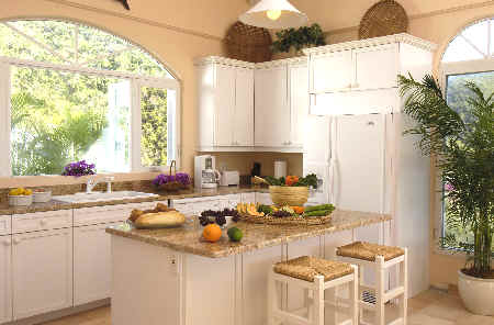 A bright kitchen featuring white cabinets and a large window that allows natural light to fill the space.