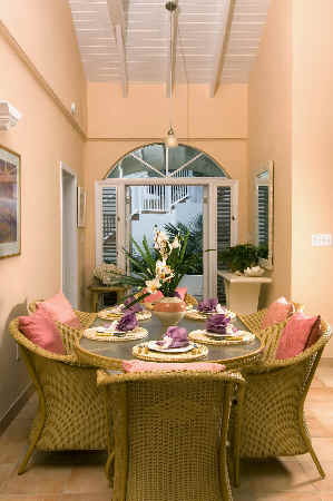 A dining room featuring wicker chairs surrounding a wooden table, creating a cozy and inviting atmosphere.