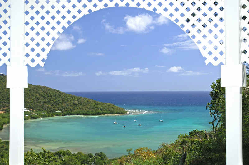 View of the ocean through a white lattice gazebo arch, overlooking Fish Bay in St. John, U.S. Virgin Islands.